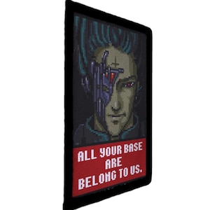 May include: A rectangular patch featuring a pixelated portrait of a cyborg with teal hair and a cybernetic eye. Below the image, the text "ALL YOUR BASE ARE BELONG TO US" is displayed on a red background.