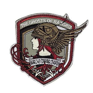 May include: Embroidered patch featuring a profile of a woman in a winged helmet, with red hair. The patch has the text "THE GHOSTS OF RAZGRIS" and "RAZGRIS AIR COMMAND SQUADRON" on a shield-shaped design with red, brown, and gray accents.