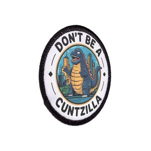 May include: A circular patch with a black border. The text "DON'T BE A" arcs across the top, and "CUNTZILLA" is at the bottom. A cartoon dinosaur stands before a city skyline in the centre.