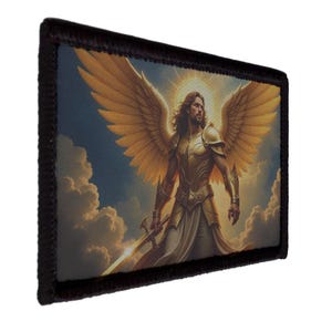 May include: A rectangular patch with a black border features a detailed illustration of an angel. The angel has golden wings, armor, and a sword, set against a backdrop of clouds and a bright light. The artwork has a painterly style.