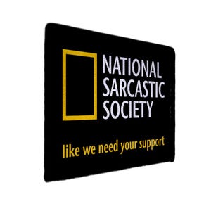 Könnte beinhalten: Schwarzes rechteckiges Schild mit dem Text "NATIONAL SARCASTIC SOCIETY" in Weiß und "like we need your support" in Gelb. Das Schild hat einen gelben quadratischen Rahmen auf der linken Seite.