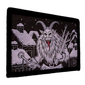 以下が含まれることがあります： 黒い縁取りの長方形パッチには、クランプスのイラストが描かれています。この画像は、角があり、毛むくじゃらの生き物が長い赤い舌を持ち、枝と鎖を持っている様子を示しています。雪の降る屋根と星が背景を埋め、冬のシーンを作り出しています。