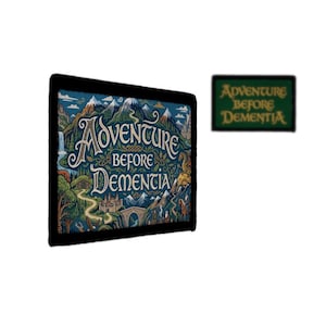 May include: A rectangular wall art piece with a black frame featuring a landscape illustration of mountains, a castle, and a winding path with the text Adventure Before Dementia. A smaller matching rectangular patch is positioned to the right.