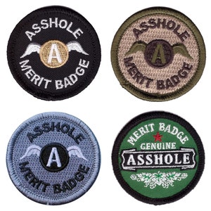 May include: Four embroidered patches with the text "ASS HOLE MERIT BADGE". Each patch has a circular design with the text in a curved font. The patches are black, olive green, light blue, and dark green.
