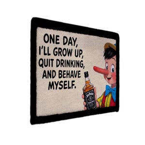 May include: Rectangular patch with a black border featuring the text "ONE DAY, I'LL GROW UP, QUIT DRINKING, AND BEHAVE MYSELF." A cartoon Pinocchio figure holds a bottle of Jack Daniel's whiskey.