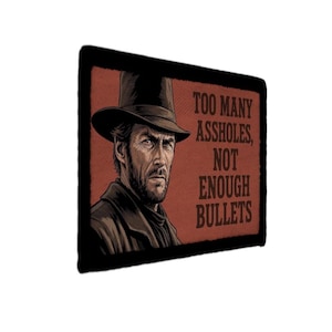 Könnte beinhalten: Rechteckiger Aufnäher mit einem Porträt eines Mannes mit Hut und dem Text "TOO MANY ASSHOLES, NOT ENOUGH BULLETS" in braunen Buchstaben auf rotem Hintergrund. Der Aufnäher hat einen schwarzen Rand.