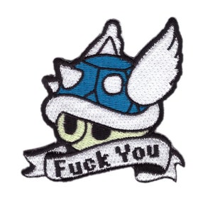 Op de afbeelding: Geborduurde patch met een cartoon schildpadschildontwerp in blauw, wit en zwart. De patch heeft de tekst "Fuck You" op een banner. Geschikt voor toepassing op kleding of accessoires.