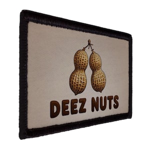 May include: Rectangular patch with a tan background and a black border. The patch features a graphic of two peanuts and the text "DEEZ NUTS" in brown letters. The peanuts are detailed with brown and tan shading.