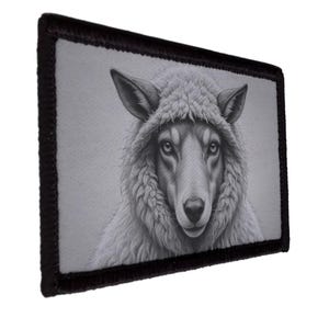 Peut inclure: Un écusson rectangulaire avec une illustration en niveaux de gris d'un loup portant un capuchon de mouton. Le visage du loup est détaillé avec de la fourrure et des yeux expressifs. L'écusson a une bordure noire.
