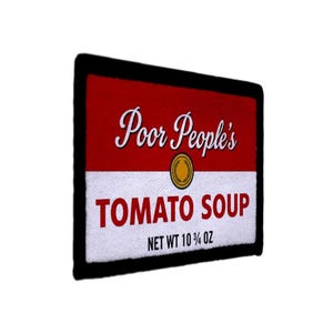 Könnte beinhalten: Ein rechteckiger Aufnäher mit rotem Oberteil und weißem Unterteil. Der Text "Poor People's" steht in weißer Schrift über "TOMATO SOUP" in roten Blockbuchstaben. Zwischen den Texten befindet sich ein goldenes Emblem. Der Aufnäher lautet "NET WT 305 g".