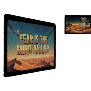 May include: Rectangular black framed art print with the text "FEAR IS THE MIND KILLER" in gold lettering. The artwork depicts a desert landscape under a starry sky with a planet and a figure walking in the distance.