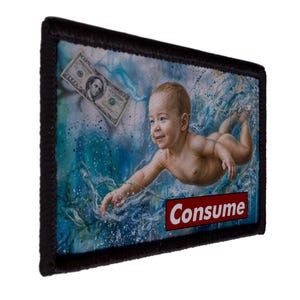 May include: A rectangular patch with a black border. The image depicts a baby swimming in blue water with a dollar bill floating nearby. The word "Consume" is in a red box at the bottom.