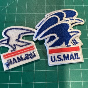 Puede incluir: Parches bordados con el logotipo de U.S. Mail, un dise&ntilde;o de &aacute;guila azul, detalles en rojo y blanco, y el texto "U.S. MAIL". Los parches est&aacute;n sobre una superficie de cuadr&iacute;cula verde.