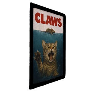 May include: A rectangular sign with a black border features a parody of the movie "Jaws." The word "CLAWS" is in red block letters above a cat in water, reaching out with its paw towards a mouse. The cat has a surprised expression.