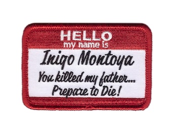 Op de afbeelding: Een rechthoekige rode en witte patch met de tekst "HELLO my name is Inigo Montoya You killed my father... Prepare to Die!" in zwart en wit. De patch heeft een rode rand.