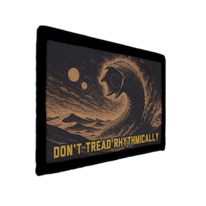May include: A rectangular patch with a black border featuring a desert scene with a large worm-like creature. The text "DON'T TREAD RHYTHMICALLY" is in yellow at the bottom. The artwork is in shades of brown and tan.