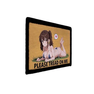 Op de afbeelding: Een rechthoekige patch met een zwarte rand. De patch toont een anime-achtige illustratie van een vrouw in bikini die op gras ligt. De tekst "PLEASE TREAD ON ME" staat onder de illustratie.