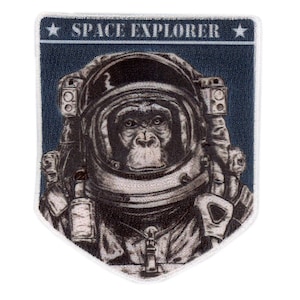 May include: A navy blue patch featuring a chimpanzee in a space suit. The chimpanzee's face is visible inside the helmet. The text "SPACE EXPLORER" is printed in white above the chimpanzee.