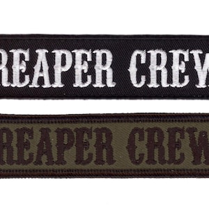 May include: Two rectangular patches with the text "REAPER CREW". One patch is black with white embroidered lettering. The other is olive green with brown embroidered lettering. Both patches have a stitched border.