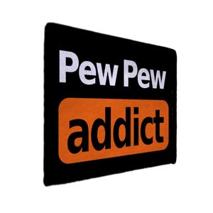 Peut inclure: Un rectangle noir avec les mots "Pew Pew" en blanc au-dessus du mot "addict" en orange. Le mot "addict" est dans un rectangle arrondi.