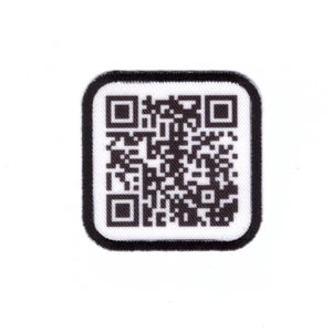 May include: A square patch featuring a black and white QR code. The code is surrounded by a black border and set against a white background. The patch is likely for apparel or accessories.