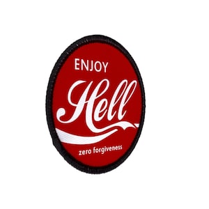 May include: A round, red patch with the words "ENJOY Hell" in white script, and the phrase "zero forgiveness" in white. The patch has a black border and a white background.