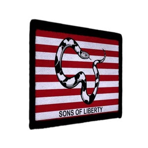 May include: A square patch with a black border features a red and white striped background. A stylized black and white snake is coiled over the stripes. The words "SONS OF LIBERTY" are printed in white at the bottom.