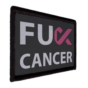May include: Black rectangular patch with white text reading "FUCK CANCER". The word "FUCK" is in a bold, sans-serif font. The "U" is replaced with a pink cancer ribbon. The word "CANCER" is also in white.