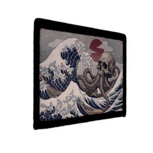 May include: A rectangular patch featuring a skull with octopus tentacles emerging from the skull, set against a backdrop of a large ocean wave. The design incorporates shades of gray, blue, and red, with a black border.