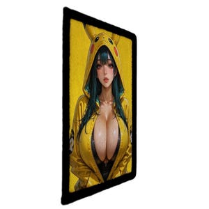 May include: A rectangular patch with a digital illustration of a person in a yellow Pikachu hoodie. The person has long teal hair and is set against a yellow background. The patch is framed by a black border.