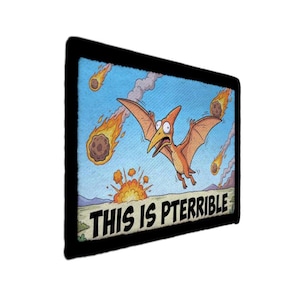 May include: A rectangular patch with a black border featuring a cartoon pterodactyl fleeing from fiery meteors. The text "THIS IS PTERRIBLE" is displayed at the bottom, set against a blue sky background.