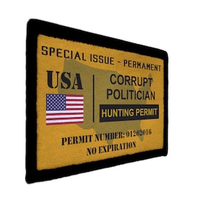 May include: A rectangular patch with a black border and a yellow background. The patch features the text "SPECIAL ISSUE - PERMANENT", "USA", an American flag, and "CORRUPT POLITICIAN HUNTING PERMIT". The permit number is 01202016, with "NO EXPIRATION".