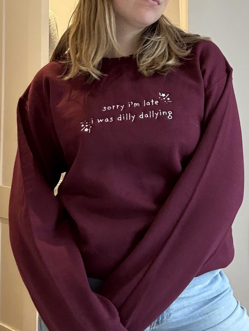 May include: A maroon sweatshirt with white text that reads "sorry i'm late *sparkles* i was dilly dallying *sparkles*"