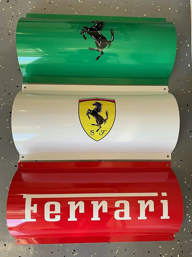 May include: Three metal signs stacked vertically. The top sign is green with a black prancing horse logo. The middle sign is white with a yellow shield containing a black prancing horse logo and the letters "SF". The bottom sign is red with the word "Ferrari" in white letters.