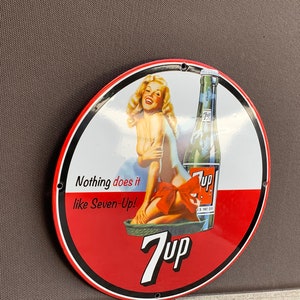 Soda pop porcelain enamel sign with pinup girl