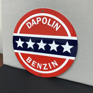 May include: A red and blue circular sign with the text "DAPOLIN BENZIN" and five white stars.