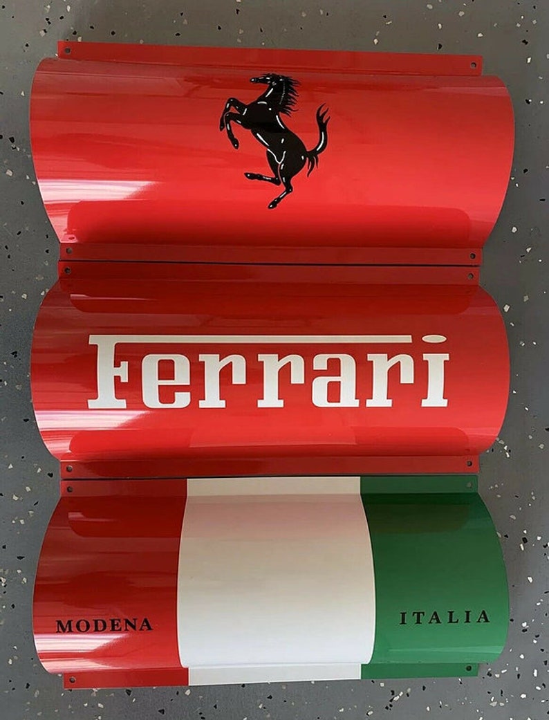 May include: A red, white, and green metal sign with the Ferrari logo, the word "Ferrari" in white letters, and the words "MODENA" and "ITALIA" in black letters.
