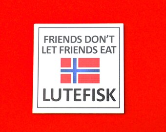 Pode incluir: Copo de apoio quadrado branco com o texto "FRIENDS DON'T LET FRIENDS EAT LUTEFISK" e uma bandeira norueguesa vermelha, branca e azul.