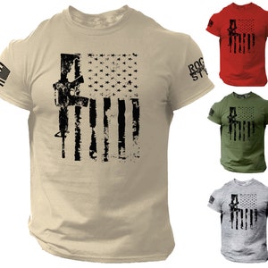 May include: Crew neck t-shirts in tan, red, green, and gray, each featuring a distressed American flag design with a rifle silhouette. The left sleeve displays the American flag, and the right sleeve has the text "ROCK STYLE".