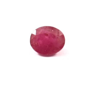 May include: A vibrant pink oval-shaped gemstone with a faceted cut.
