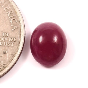 Puede incluir: Una piedra preciosa cabujón de color rojo intenso, aproximadamente del tamaño de una moneda de 25 centavos de dólar estadounidense.