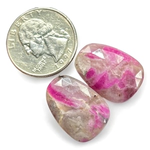 Puede incluir: Dos piedras preciosas cabujón de color rosa y blanco con un corte facetado. Las piedras son aproximadamente del tamaño de una moneda de 25 centavos de dólar estadounidense.
