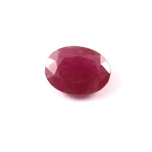May include: A deep red oval-shaped gemstone with a faceted cut.