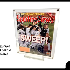 May include: A framed magazine cover of Sporting News with the headline "SWEEP!" featuring a group of baseball players celebrating a victory. The magazine cover is in a clear acrylic frame with a UV blocking feature.