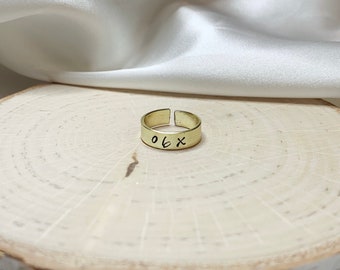 May include: An adjustable ring made of gold metal with the inscription "06X" on the band.
