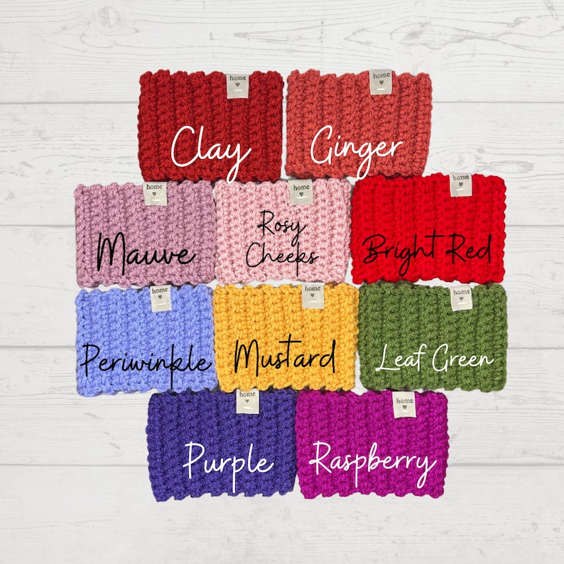 May include: A set of ten crocheted headbands in various colours, including clay, ginger, mauve, rosy cheeks, bright red, periwinkle, mustard, leaf green, purple, and raspberry. Each headband has a small tag with the word "home" on it.