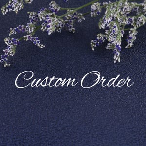 May include: A blue background with white text that reads "Custom Order" and a sprig of dried flowers with purple and white blooms.