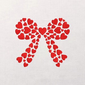 Puede incluir: Diseño de lazo de corazón rojo bordado sobre fondo blanco. El lazo está compuesto por numerosos corazones pequeños, creando una estética texturizada y romántica. Adecuado para el Día de San Valentín u otras celebraciones.