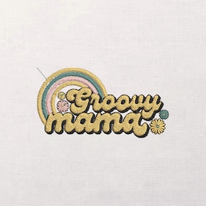 Puede incluir: Diseño bordado con la frase "Groovy Mama" en una fuente retro, acompañado de un arcoíris y detalles florales. El diseño utiliza colores amarillo, rosa, azul y verde, ideal para ropa o decoración del hogar.