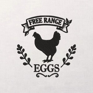 Może przedstawiać: Czarny haft na białym tle. Projekt przedstawia sylwetkę kurczaka, słowa "FREE RANGE" w banerze i słowo "EGGS" poniżej. Ozdobne gałązki otaczają kurczaka.
